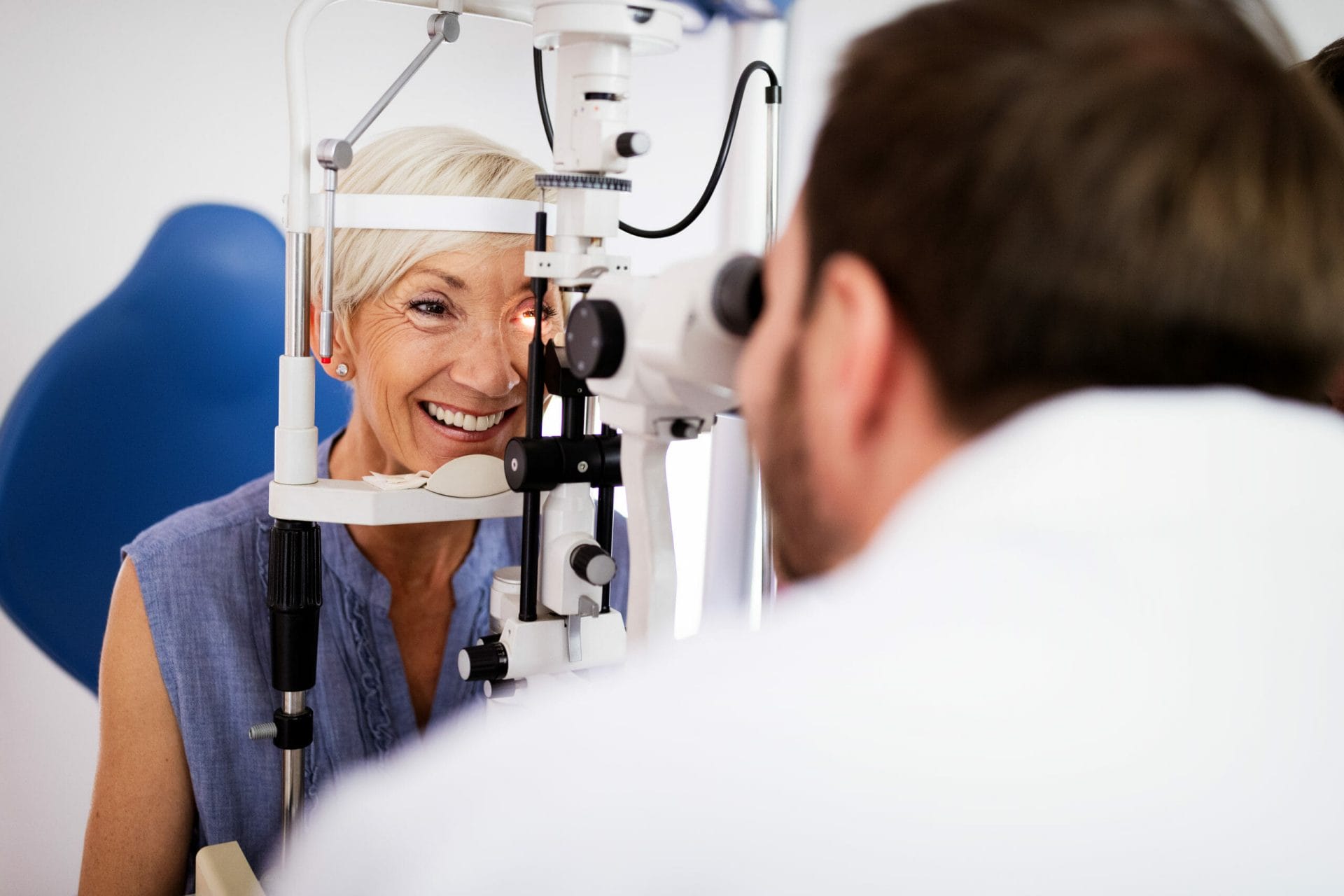 Optometrist examining mature woman in modern ophthalmology clinic